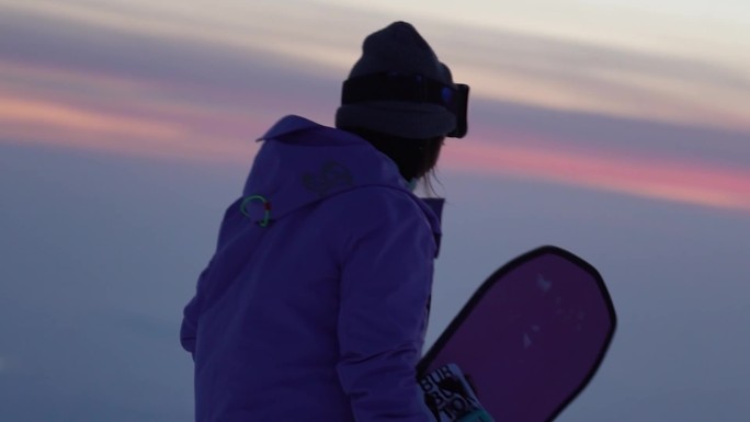 滑雪的女孩在山顶看晚霞