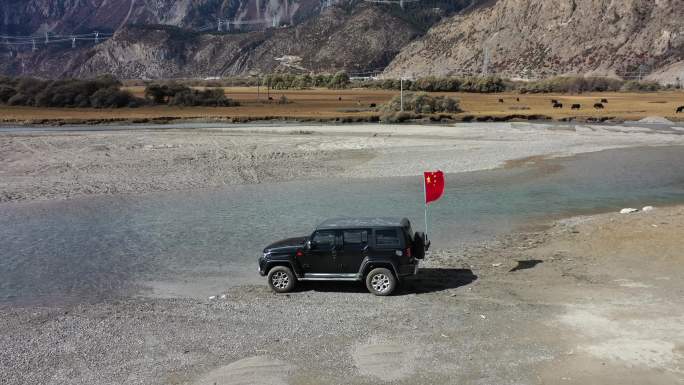 西藏然乌湖河滩里行驶的越野车
