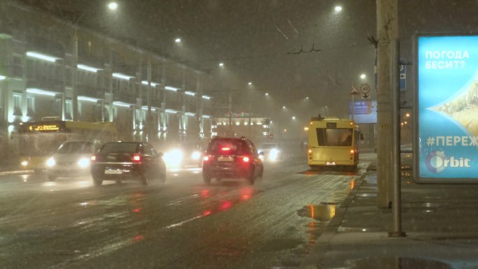 冬天夜晚城市下雪的车流街道