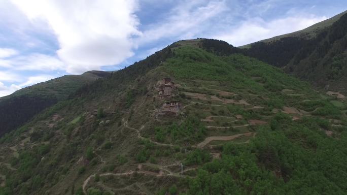 高原航拍盘山路和山坡上的建筑