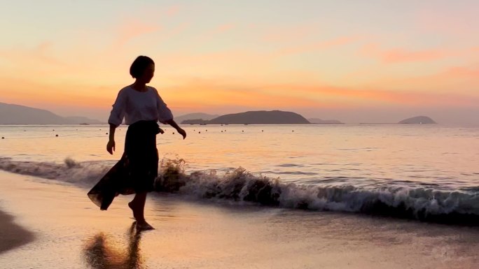 海边早晨朝霞少女漫步海滩