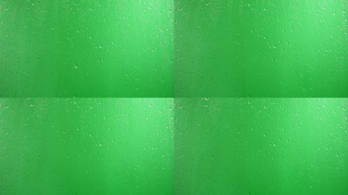 水滴沿着绿色背景的玻璃流下
