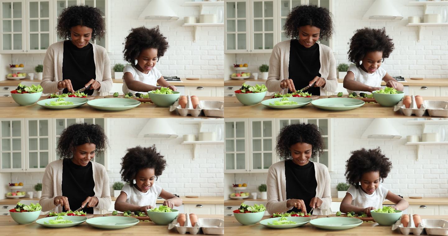 可爱的女儿在厨房帮妈妈切蔬菜沙拉