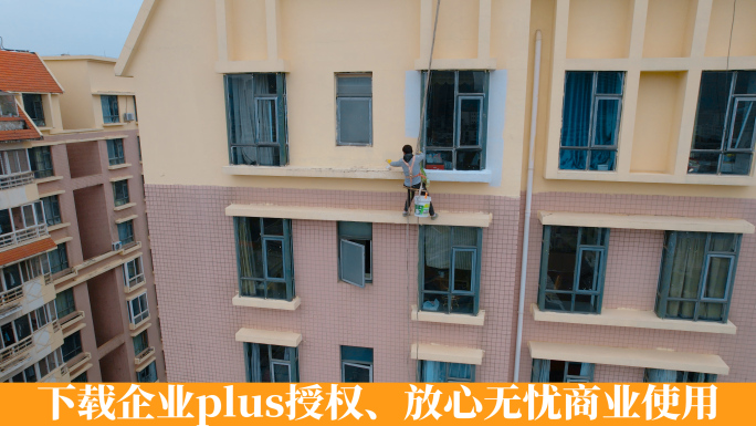 挂在高楼上进行外墙装饰粉刷的工人蜘蛛人