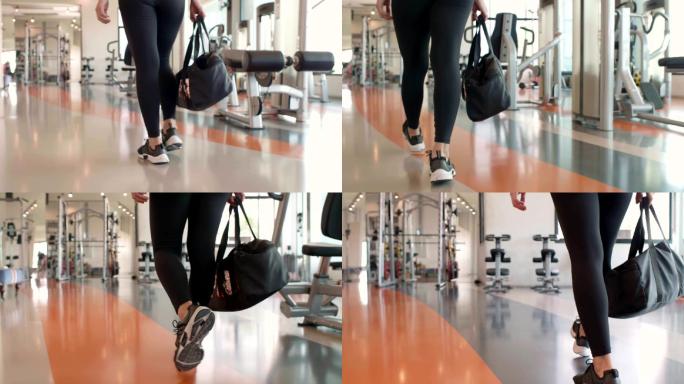 女运动员带着装备袋走进健身房进行训练