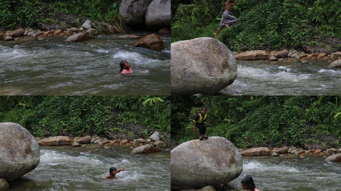 山里的小孩跳入水中 溪流里玩耍的孩子