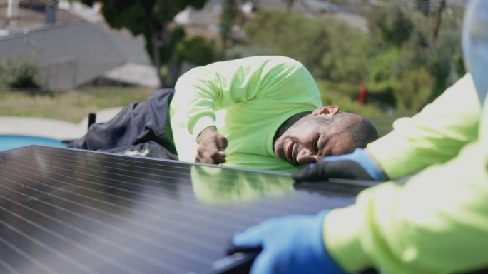 屋顶安装太阳能电池板的工人团队
