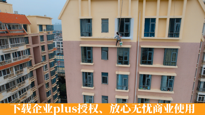 挂在高楼上粉刷外墙的工人蜘蛛人
