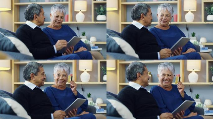 一对老年夫妇在家沙发上使用数字平板电脑