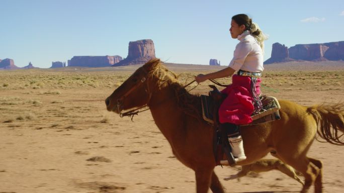 少女骑着她的马在沙漠上疾驰