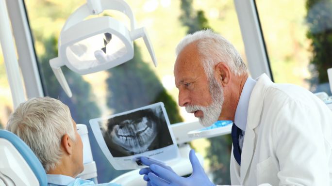 一名男性牙医检查一名老年女性患者的特写镜