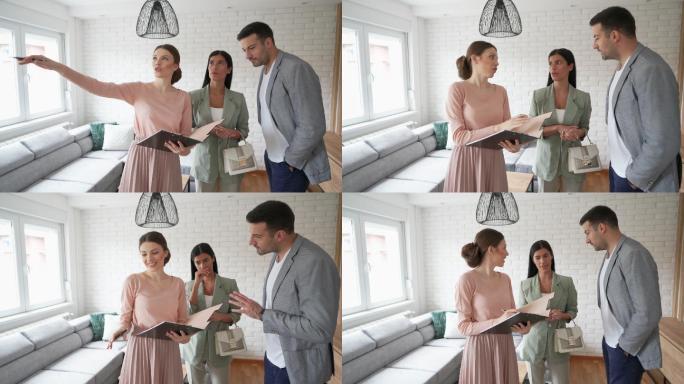 房地产经纪人向一对年轻夫妇展示公寓出售