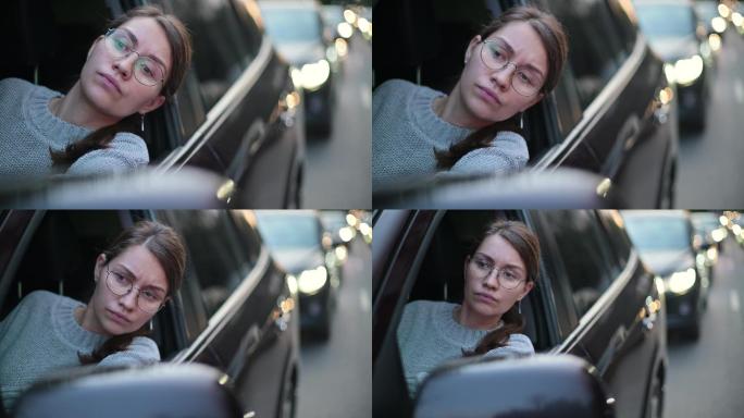 一位年轻女子在交通堵塞时透过车窗观看