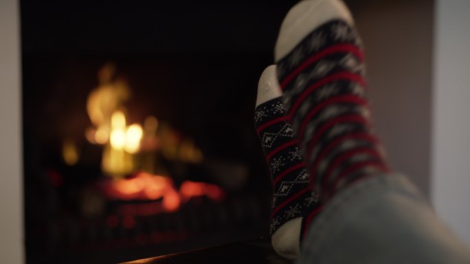 妇女在家里穿着袜子在壁炉旁休息