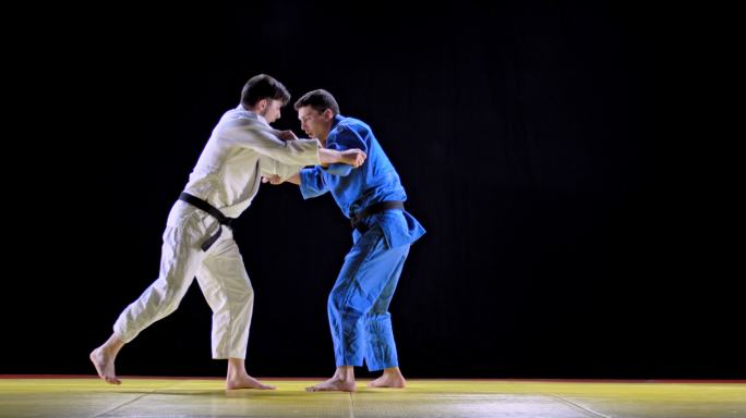 两名男子柔道选手在榻榻米上搏斗