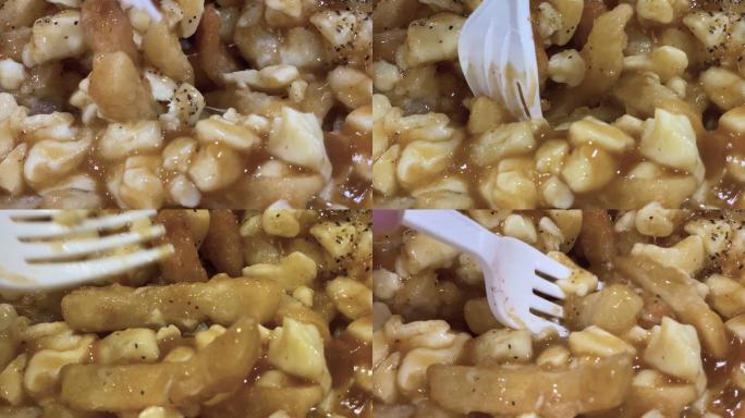 塑料叉在poutine（魁北克著名菜肴）中挖掘的动作