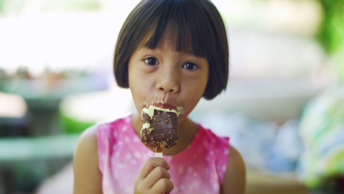 可爱的女孩正在吃巧克力冰淇淋零食