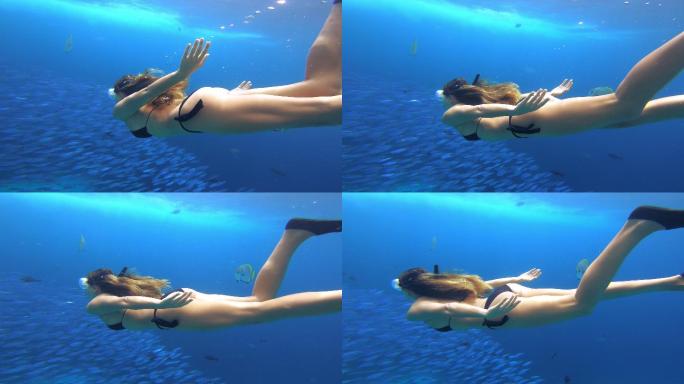 女子独自在鱼群旁浮潜的4k视频片段