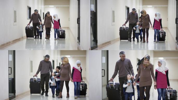 一家人拉着行李在走廊上