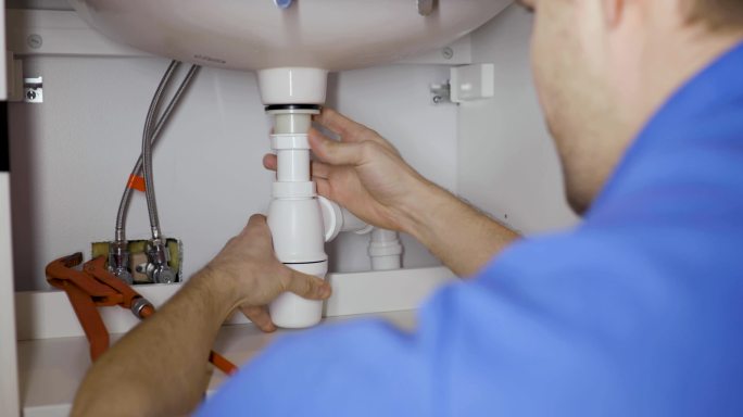 水管工在家庭浴室安装水槽虹吸管