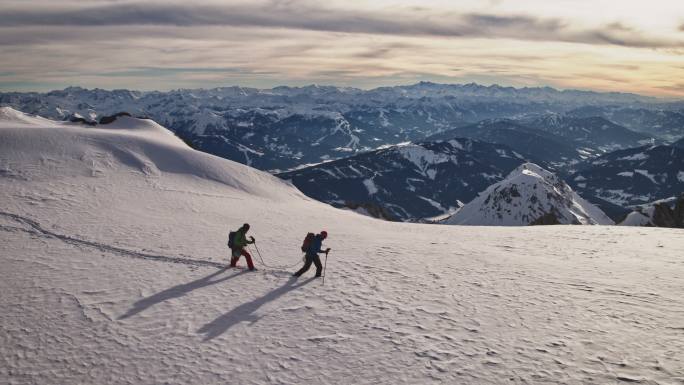 徒步旅行者在白雪覆盖的悬崖上行走