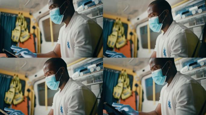 护理人员戴着口罩在救护车中使用平板电脑