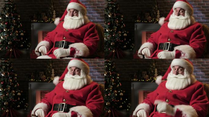 圣诞老人正坐在壁炉旁对着摄像机眨眼
