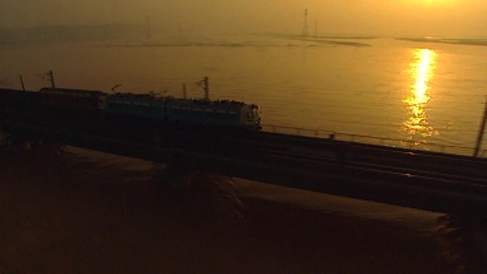 火车迎着夕阳在江桥上奔驰