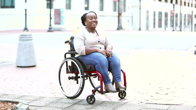 坐轮椅的女人对着镜头微笑