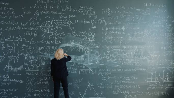 聪明的女研究员在课堂上走向黑板写公式