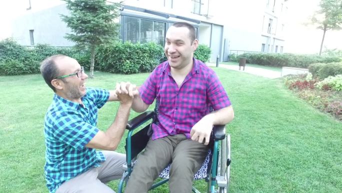 父亲和坐轮椅的残疾小男孩