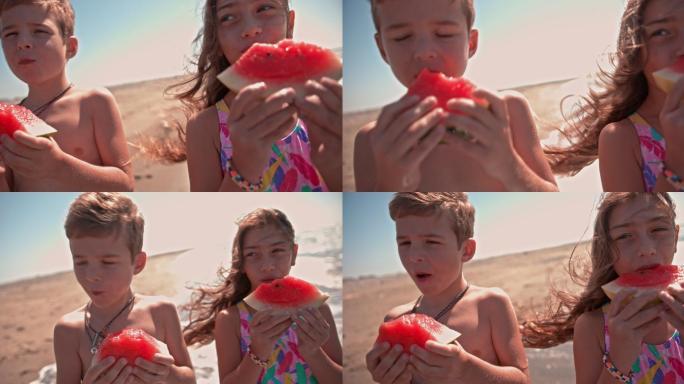 快乐的男孩和女孩在海滩上吃西瓜
