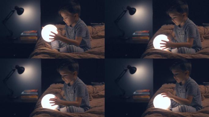 一个孩子坐在床上，手里拿着一轮明月。