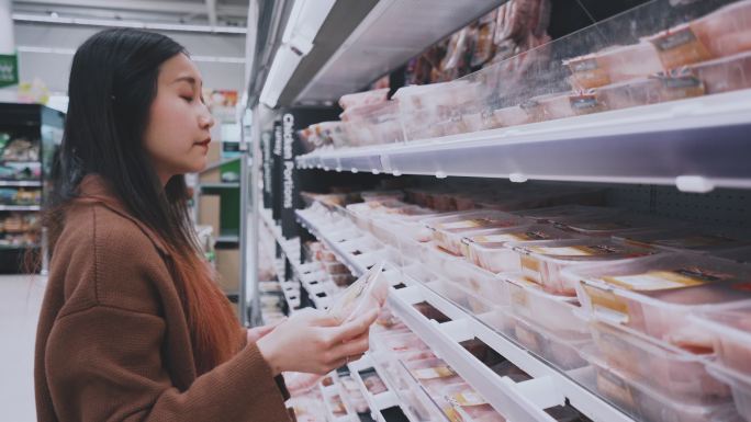 年轻女子选择在超市买肉