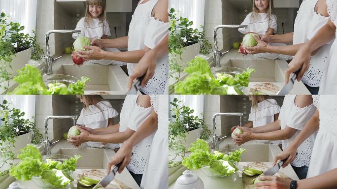 妈妈和女儿一起在厨房水槽里洗蔬菜
