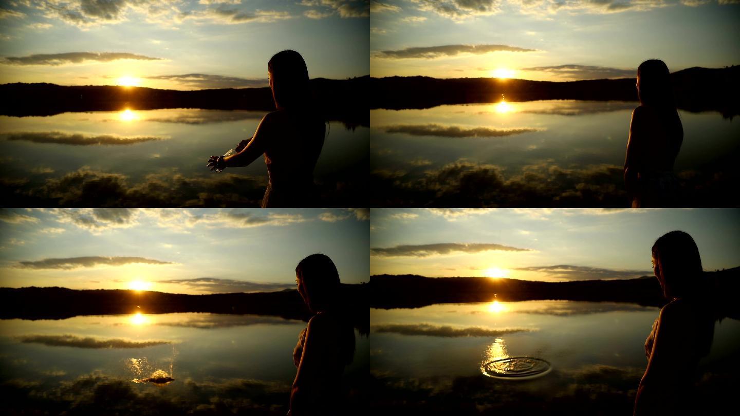 日落时，年轻女子将一个信息瓶扔进水中