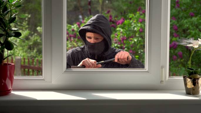 窃贼从窗户闯入一所房子