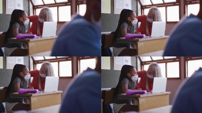 老师和女孩在学校上课时使用笔记本电脑