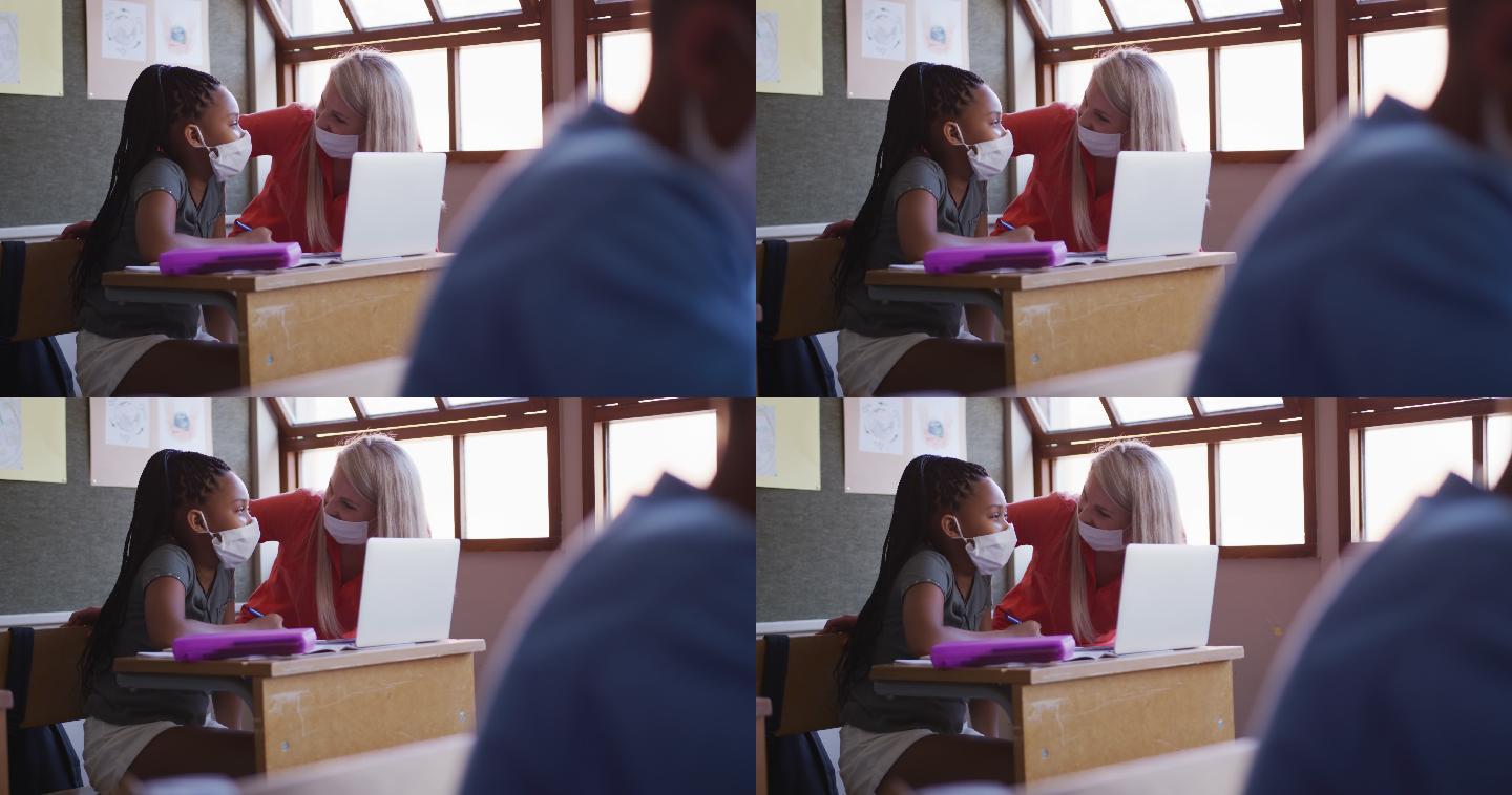 老师和女孩在学校上课时使用笔记本电脑