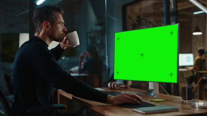 男子在办公室看着电脑绿色屏幕