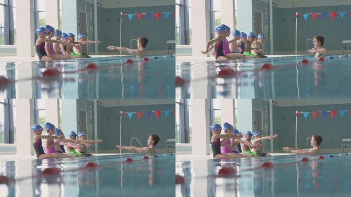游泳课上，男教练给在游泳池边上的孩子讲解