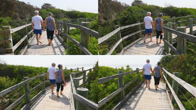 一对老年夫妇在海滩的木板路上散步
