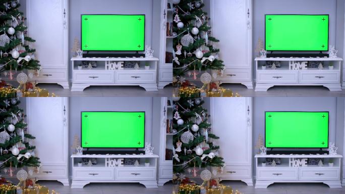 客厅圣诞树旁带绿色屏幕的智能电视