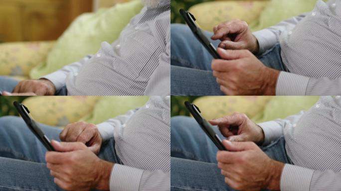一位老人手持数字平板电脑的特写镜头