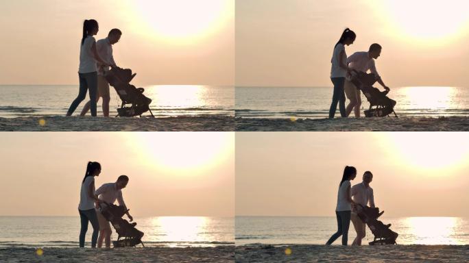 在海边散步的夫妇一家人推车婴儿车漫步在沙