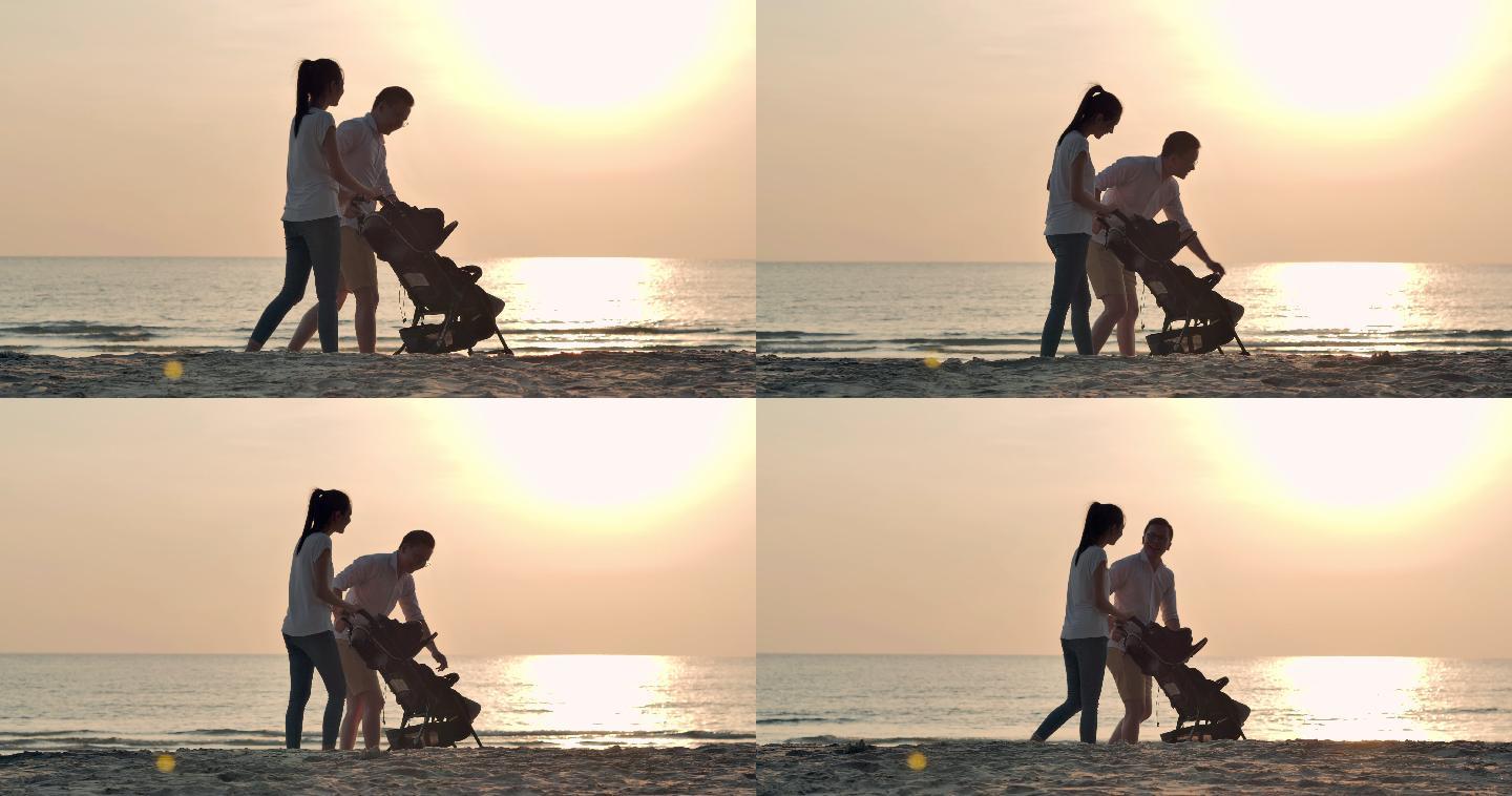 在海边散步的夫妇一家人推车婴儿车漫步在沙