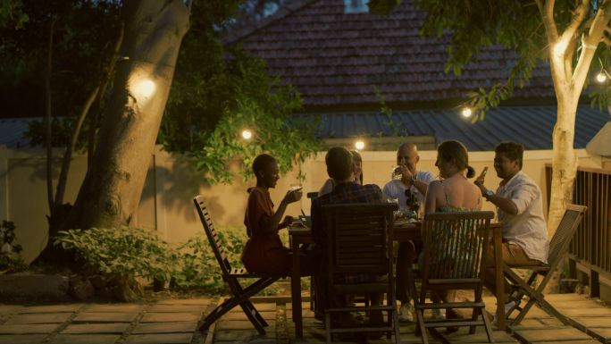 一组年轻朋友在户外晚宴上举杯祝酒