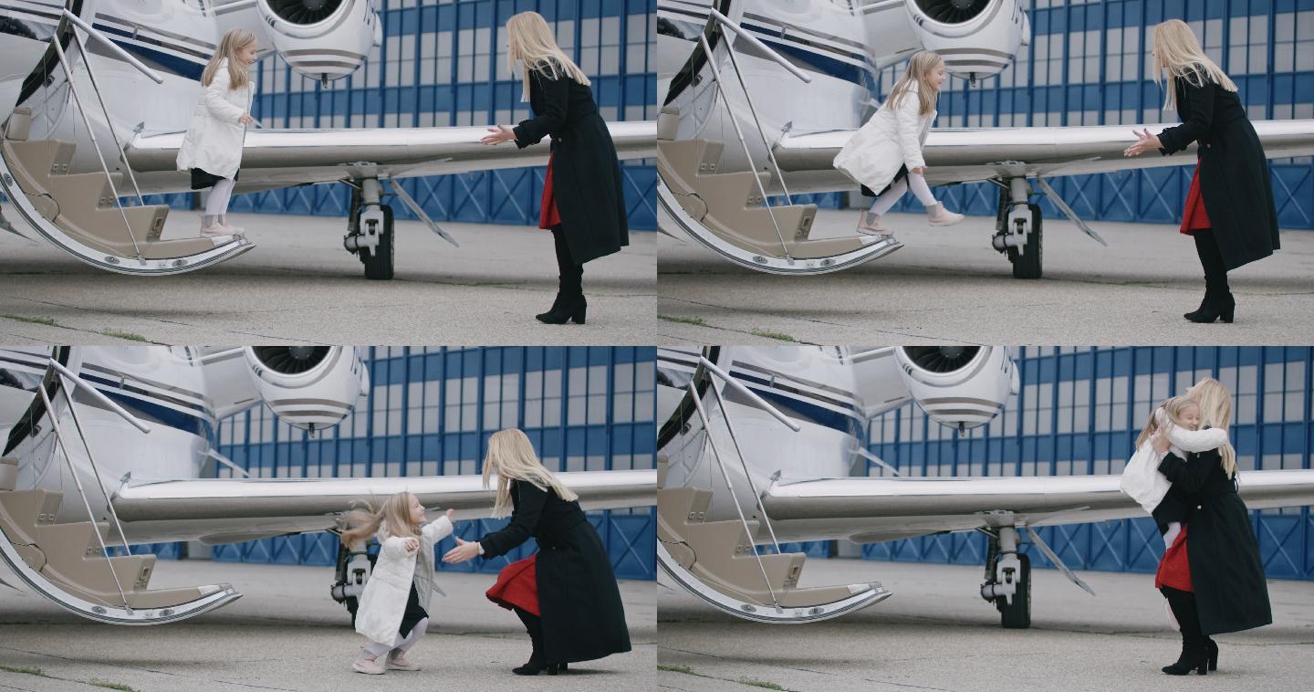 小女孩从飞机的楼梯上跳向她的母亲