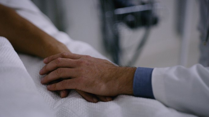 一个医生握住病人的手