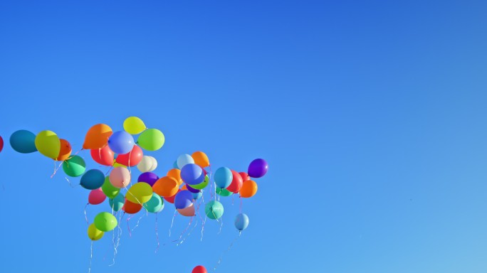 许多气球漂浮在晴朗的蓝天上